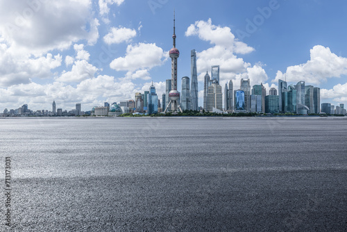 Empty asphalt road and city buildings skyline in summer