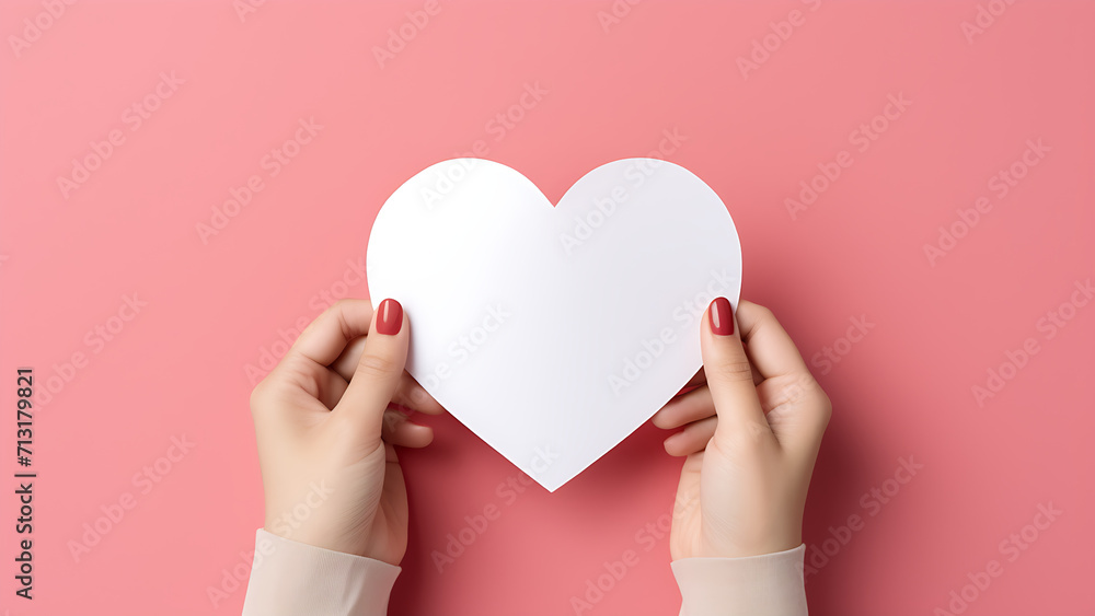 A woman's hand holds a white heart. A woman's hand holds a white heart.
