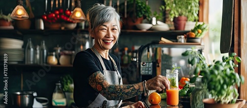 healthy asian aunt retired female woman enjoy making cook clean food breakfast for her healthy food lifestyle smiling cheerful woman silver hair with tattoo prepare smoothie juice drink for her