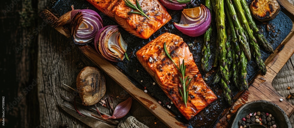 Grilled veggies on a charcoal grill Asparagus and onions caramelizing Salmon on a cedar wood plank grilling and smoking. Copy space image. Place for adding text