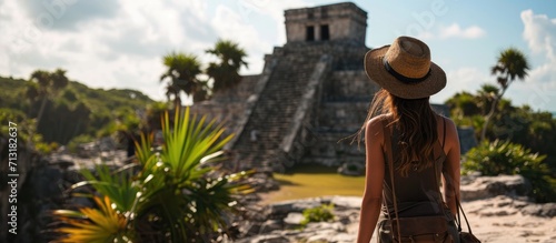 Woman tourist enjoying the view Pre Columbian Mayan walled city of Tulum Quintana Roo Mexico North America Tulum Mexico El Castillo castle the Mayan city of Tulum main temple. Copy space image photo