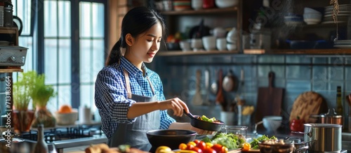 Young beauty asian woman cooking in kitchen room at home. Copy space image. Place for adding text