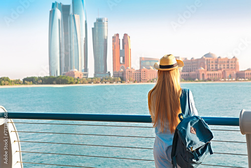 Traveler woman looking at Emirates Palace and skyscrapers of Abu Dhabi