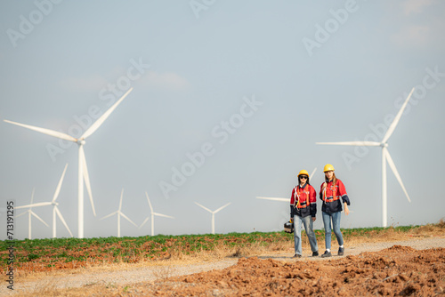 Both female engineers and wind turbines in a wind farm in the countryside of Thailand.
