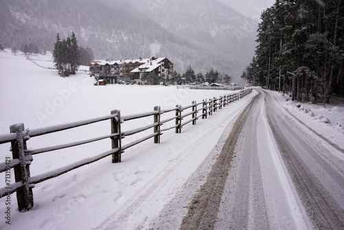 Winter road in mountains with wooden fence
