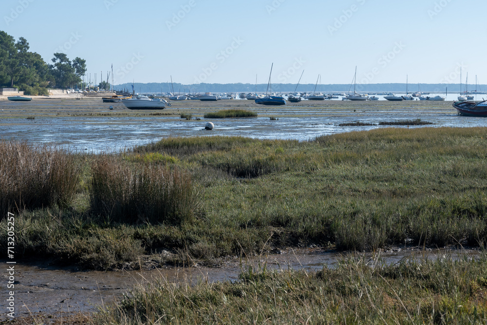 View on Arcachon Bay at low tide with many fisherman's boats and oysters farms, Cap Ferret peninsula, France, southwest of Bordeaux along France's Atlantic coastline