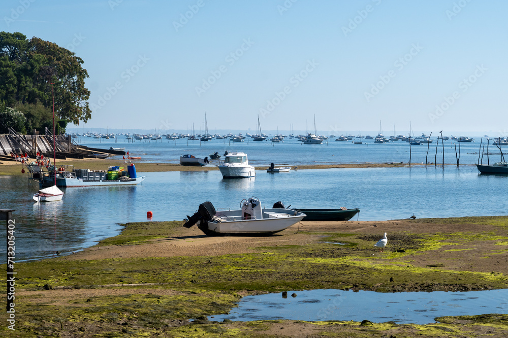 Obraz premium View on Arcachon Bay at low tide with many fisherman's boats and oysters farms, Cap Ferret peninsula, France, southwest of Bordeaux along France's Atlantic coastline