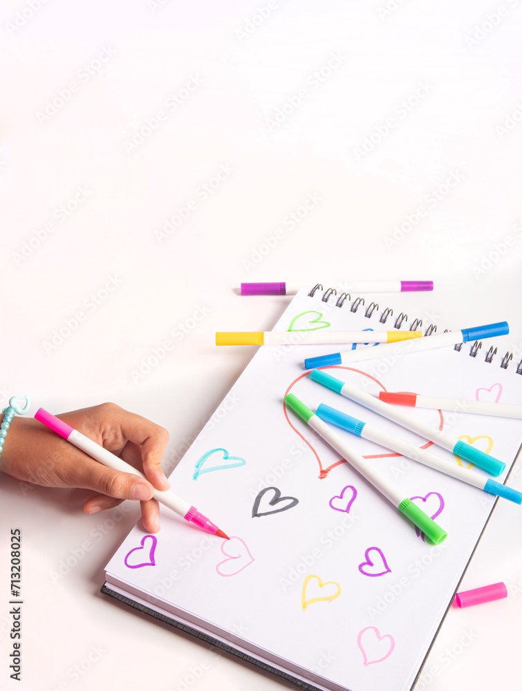 School supplies, teenager's hand drawing with markers, white background, selective focus. School supplies, teenager's hand drawing with markers, white background, selective focus.