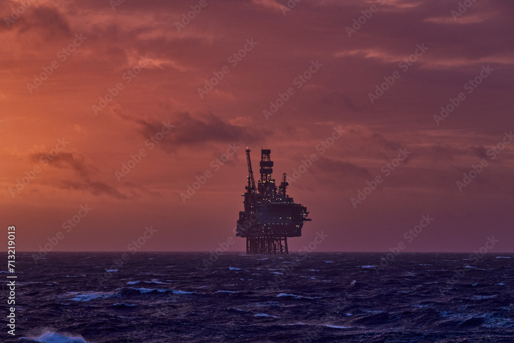 Silhouette of a jack up drilling rig in the the sea during beautiful colourful sunset in the summer