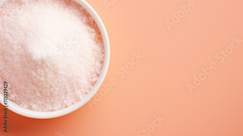 banner with copy space view from above sugar salt or white free-flowing powder against a background of peach monochromatic color. concept products, health, diet, veganism