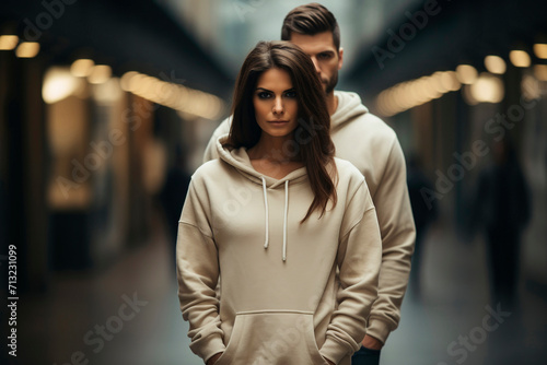 Man and woman wearing blank beige hoodie