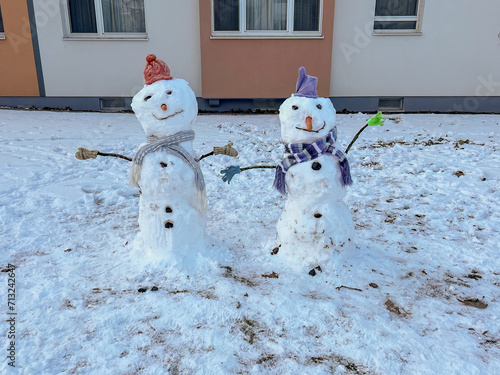 Two snow people dressed with winter clothes