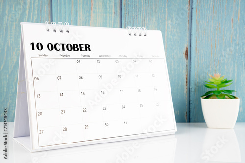 October 2024 calendar on the white table with wooden background.
