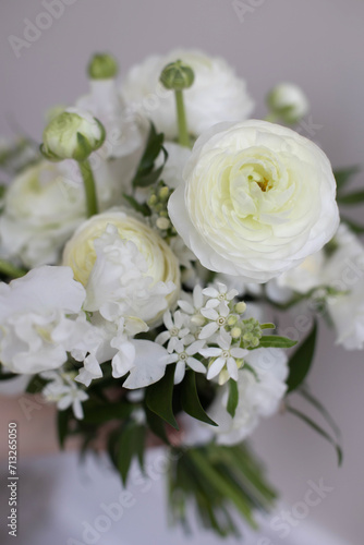 Bouquet of white peony roses in hand.