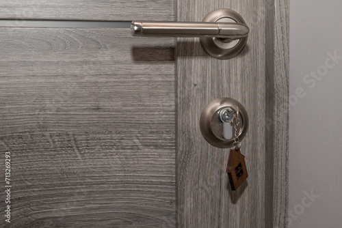 Wallpaper Mural Buy Or Rent concept. Keys with trinket in shape of house in the door keyhole. Torontodigital.ca