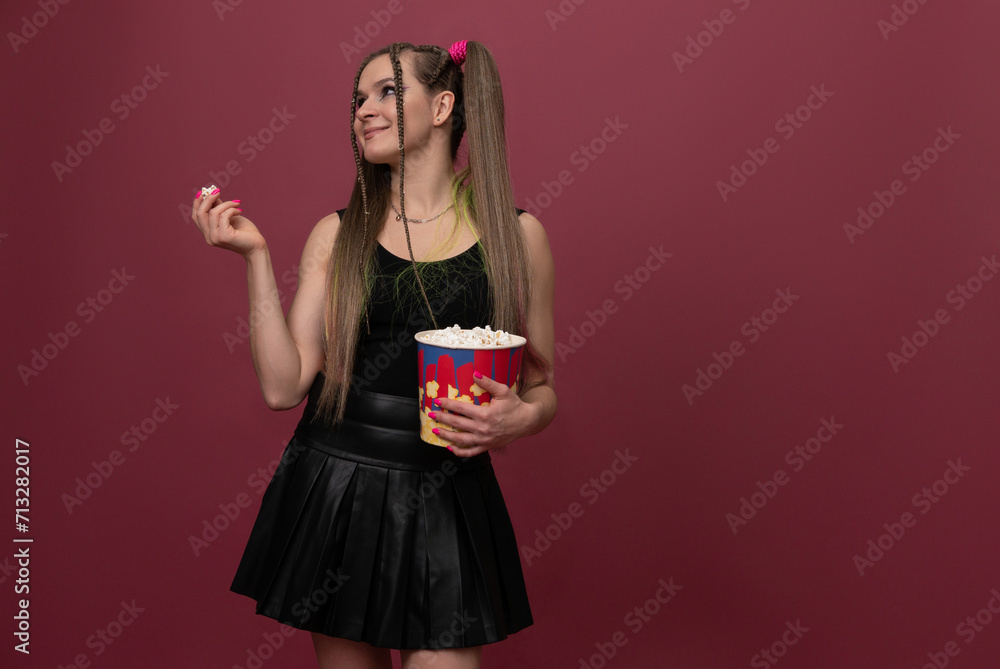 Portrait of impressed lady hand hold popcorn isolated on red color background Portrait of impressed lady hand hold popcorn isolated on red color background