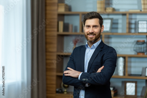 Professional mature businessman with arms crossed standing in a modern office setting, exuding confidence and experience.