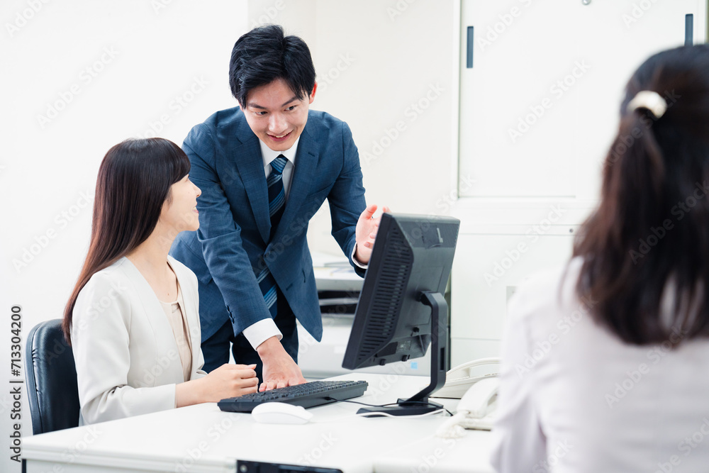 女性上司に報告をする若いビジネスマン 女性上司に報告をする若いビジネスマン