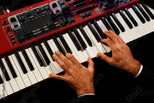 Musician hands on the modern piano keyboard keys  top view.