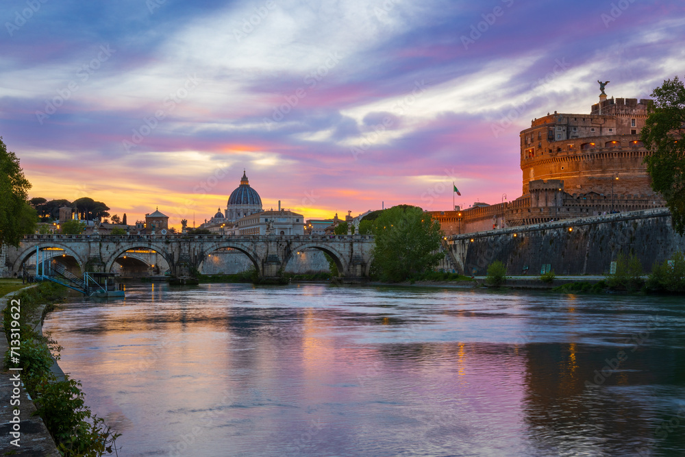 Colorful sunset with view of the Basilica of St. Peter and the Ponte Sant Angelo (Ponte Vittorio Emanuele II) in Rome, Italy