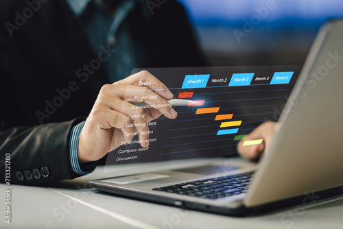 Project manager working and update tasks with milestones progress planning. Businessman using laptop computer plan schedule virtual diagram, business project management concept.