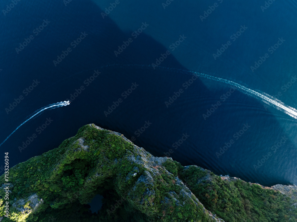 View from above, stunning aerial view of a long tail boat sailing on a blue water near Phi Phi Island. Phuket, Thailand.