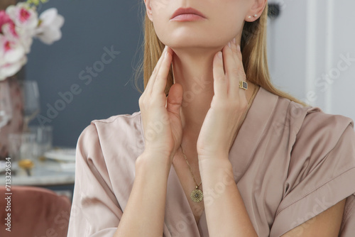 Fotografie Caucasian woman touching her throat