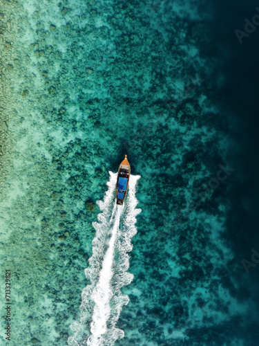 Obraz na płótnie View from above, stunning aerial view of a longtail boat sailing on a turquoise water. Phuket, Thailand. w salonie