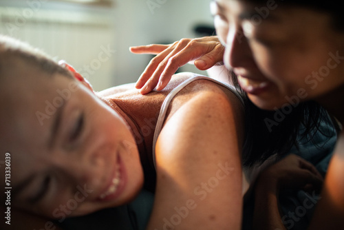 Young lesbian couple cuddling in bed photo
