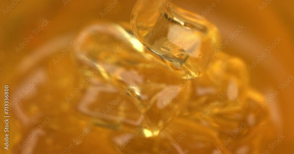 Super slow motion macro of bio organic golden sticky liquid honey is flowing and dripping at 1000 fps. Super slow motion macro of bio organic golden sticky liquid honey is flowing and dripping at 1000 fps.
