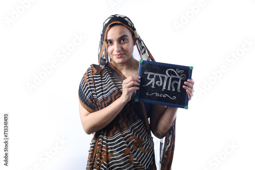 Portrait of a young Indian woman holding a writing board in hand. Bald widow in saree. Pragati written on board from chalk. © Maahir