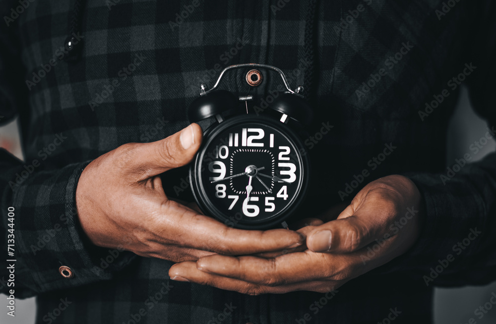 Time management concept. Man hands holding Black retro alarm clock. Time to wake up for the morning routine Time management concept. Man hands holding Black retro alarm clock. Time to wake up for the morning routine