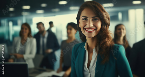 business woman smiling in office with others around her