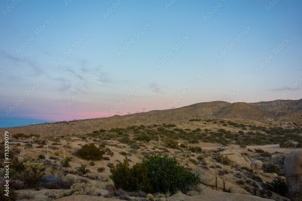 Sun setting behind the Mojave Desert hills and boulders in Apple Valley, CA
