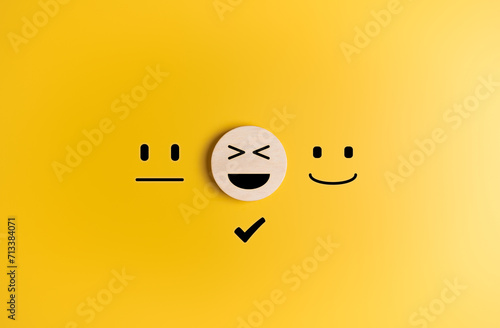 Wooden label with happy smiley face icon among emotions. Good feedback rating, satisfaction survey, customer review, user experience, mental health concept. Very please in product and service.