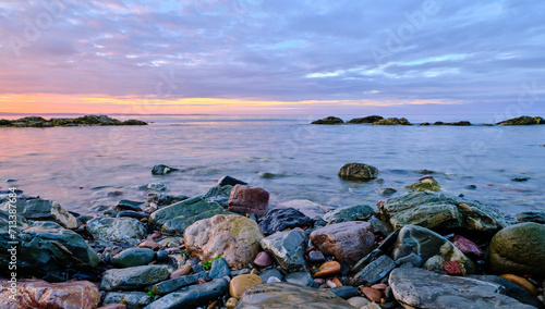 Colorful Sunset and rocks at low tide on the colorful and rocky shoreline on the Gaspe Peninsula on the Gulf of St Lawrence at the village of Perce