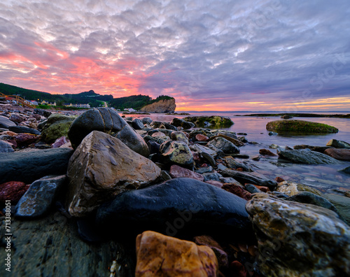 Colorful Sunset and rocks at low tide on the colorful and rocky shoreline on the Gaspe Peninsula on the Gulf of St Lawrence at the village of Perce photo