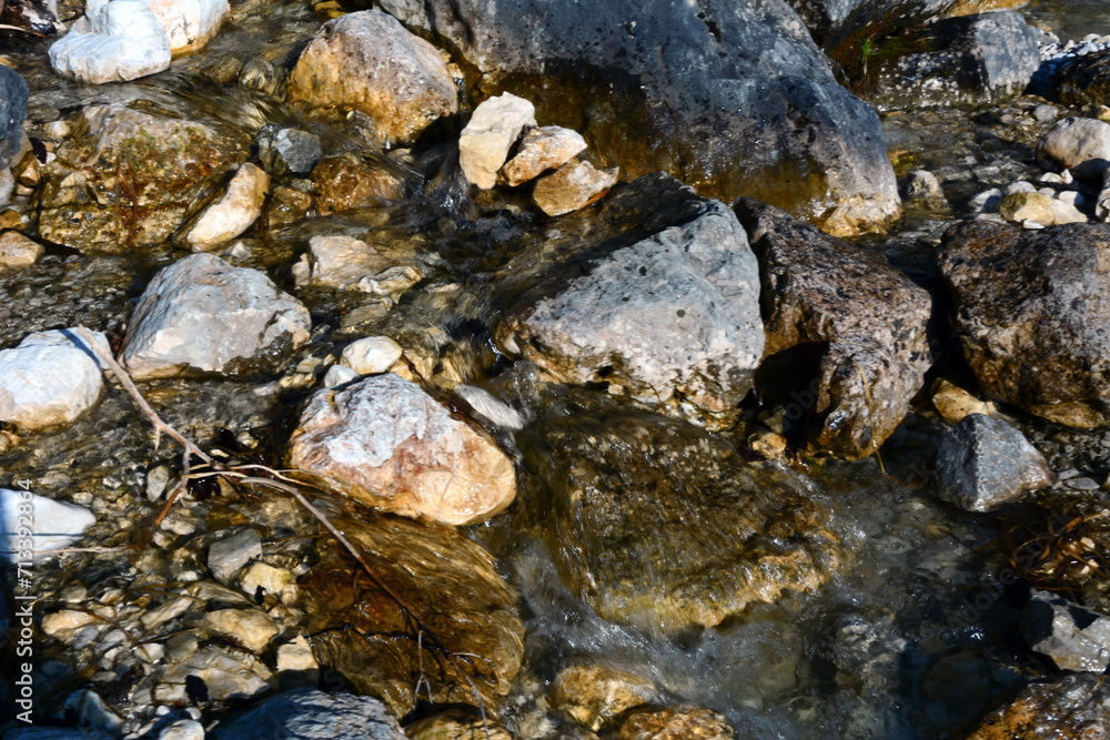 A mountain stream flows between stones. View from above A mountain stream flows between stones. View from above