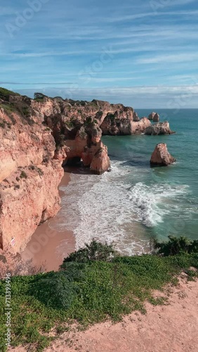 Bird's eye shot of the coast with rock formation  and waves crushing on the shore