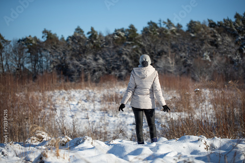 Młoda kobieta spacerująca zimą po górskim szlaku śnieżnym 