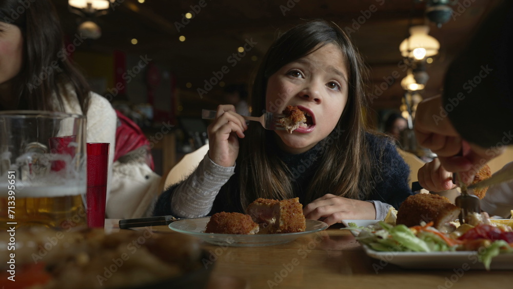 Cozy Dining Delight - Little Girl Enjoying Cordon Bleu Chicken at Family Mealtime in Wooden Interior Diner, people eating food at restaurant Cozy Dining Delight - Little Girl Enjoying Cordon Bleu Chicken at Family Mealtime in Wooden Interior Diner, people eating food at restaurant