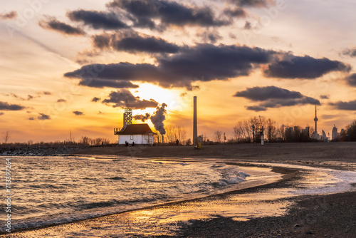 Photography sunset on icy beach in winter with dramatic clouds and  downtown skyline in dist