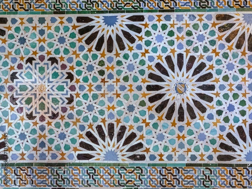 Old Islamic tiles (also known as zellige or azulejos) with traditional geometric patterns decorating a wall