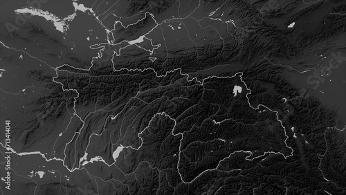 Tajikistan outlined. Grayscale elevation map photo