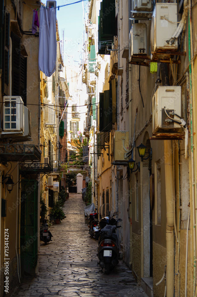 Romantic backstreet, side street or alleys in historic old town of Corfu Island, Greece with Mediterranean style architecture facades, a landmark sightseeing tourist spot in downtown Aegean Sea
