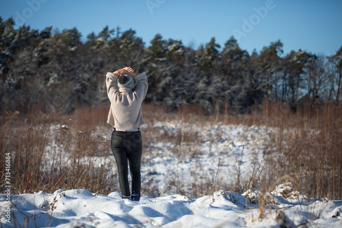 Młoda kobieta spacerująca zimą po górskim szlaku śnieżnym