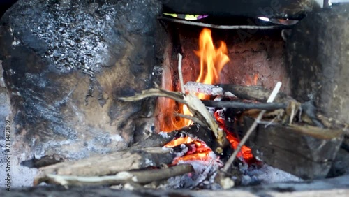 A beautiful traditional fireplace made of clay with burning wood and cast iron vessels atop of it. Uttarakhand India. photo