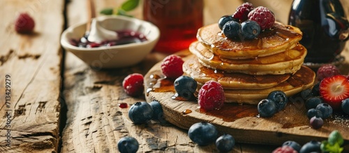 Homemade berry pancakes fresh summer dessert with blueberries on rustic wooden table close up selective focus. Copy space image. Place for adding text