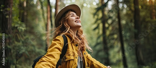 Sustainable eco friendly fashion clothes woman feeling free with open arms in woods forest happy breating clean air Travel tourist girl walking in natural healthy environment renewable resource photo