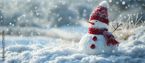 Funny snowman in stylish red hat red scalf and red gloves on snowy field. Copy space image. Place for adding text